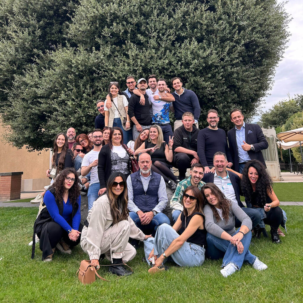 Green Finance group photo on a meadow with a shrub in the background