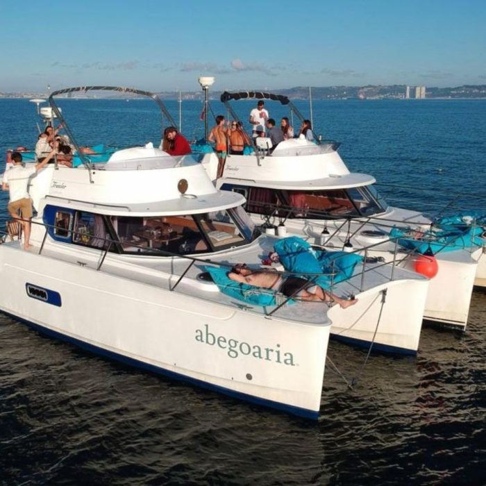 2 Boote mit Menschen auf dem Deck schwimmen nebeneinander auf dem Wasser